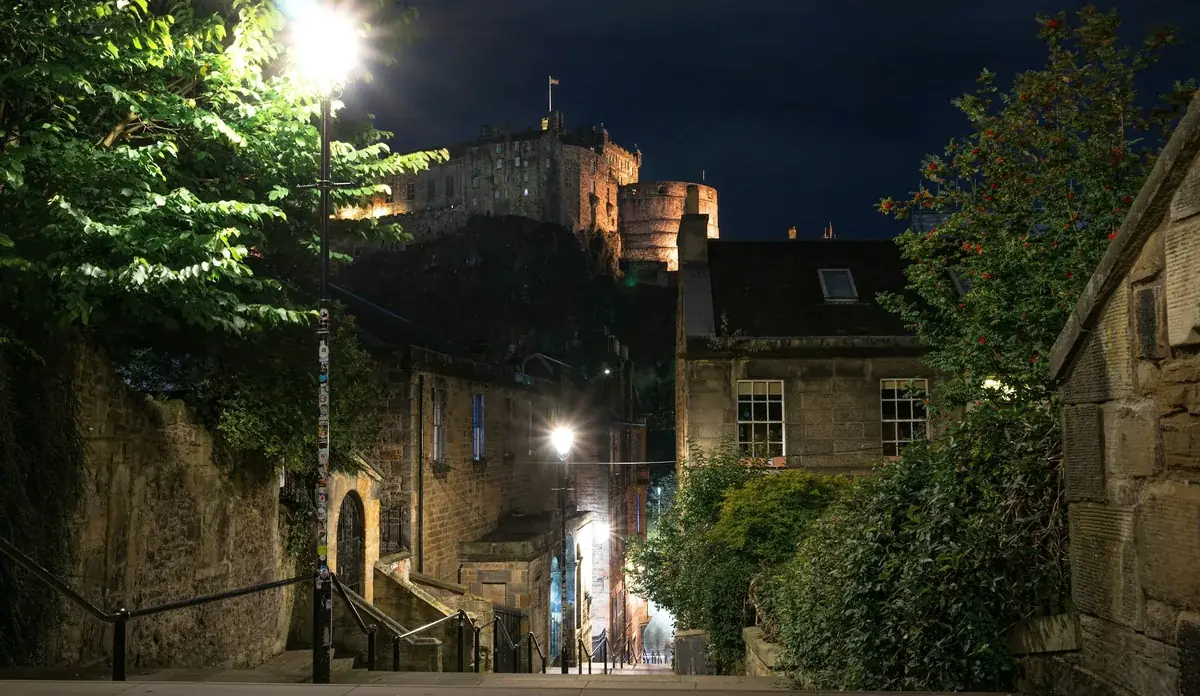 Un vicolo della Old Town di Edimburgo di sera, con il castello illuminato in alto